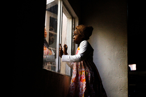 Haitian migrants talk through a window at an Evangelical Church, being used as a shelter for stranded immigrants on their way to the U.S., in Tijuana