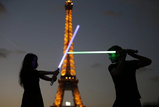 Marion and Nikola, members of the Sport Saber League, pose with their light sabers in front of the Eiffel tower in Paris, France