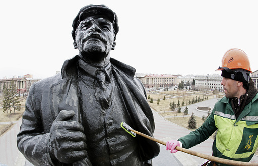 A worker washes a statue of the Soviet state founder Vladimir Lenin on the eve of his birth anniversary in Krasnoyarsk