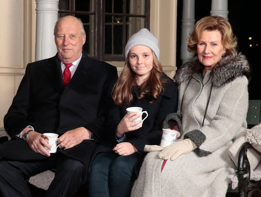 Kong Harald, prinsesse Ingrid Alexandra og dronning Sonja drikker gløgg av kopper prinsesse Astrid har malt og spiser pepperkaker utenfor lysthuset på Slottet i forbindelse med julefotografering tirsdag ettermiddag.
