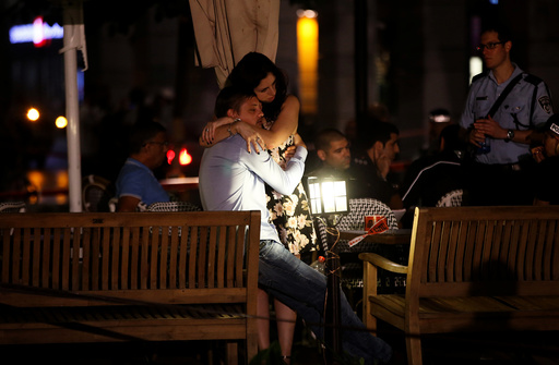 People hug each other following a shooting attack that took place in the center of Tel Aviv