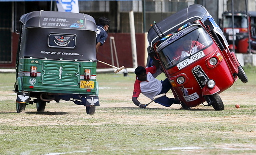 A competitor falls out from his three-wheeled vehicle during a 
