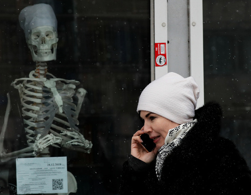 A woman walks past the window of a medical store in Kiev