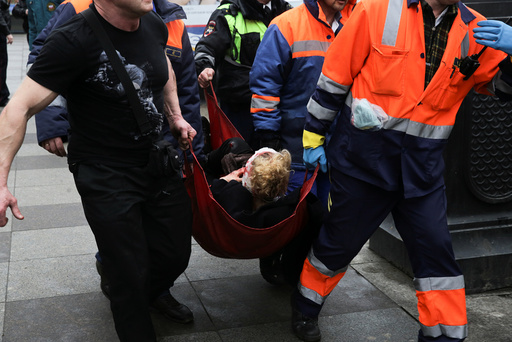 An injured person is helped by emergency services outside Sennaya Ploshchad metro station following explosions in St. Petersburg