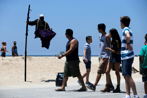 People watch a street performer in the Venice neighborhood of Los Angeles