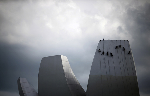 Cleaners rope down as they wash the facade of the ArtScience Museum in Singapore