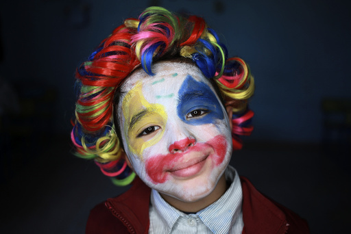A boy with clown make up poses for a picture during Children's Day celebrations, at a school in Benghazi