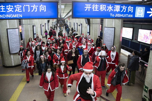 Participants dressed in Santa Claus costumes leave at a subway station to attend the SantaCon in Beijing