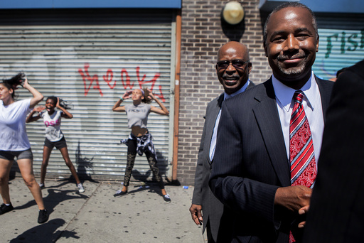 Republican presidential hopeful Ben Carson stops on the street to watch the Marching Cobras perform as he tours the Harlem area of New York.