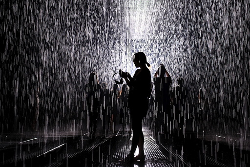 People visit the Rain Room, an installation by Random International, at a museum in Shanghai