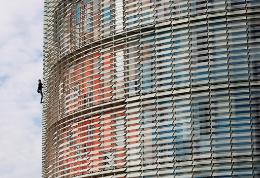 French climber Alain Robert, also known as The French Spiderman, scales the 38-story skyscraper Torre Agbar in Barcelona