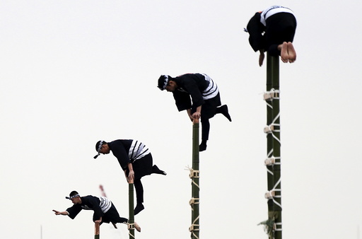 Members of the Edo Firemanship Preservation Association display their balancing skills atop bamboo ladders during a New Year demonstration by the fire brigade in Tokyo
