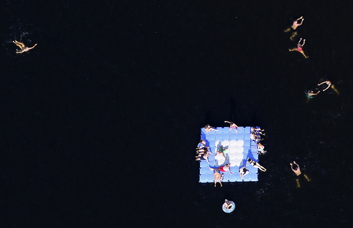An aerial view shows people relaxing on a floating platform at Silbersee lake on a hot summer day in Haltern