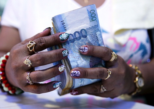 File photo of a casino financier wearing rings and with painted fingernails, counting money she collected from a gambler only moments before, in Angeles city