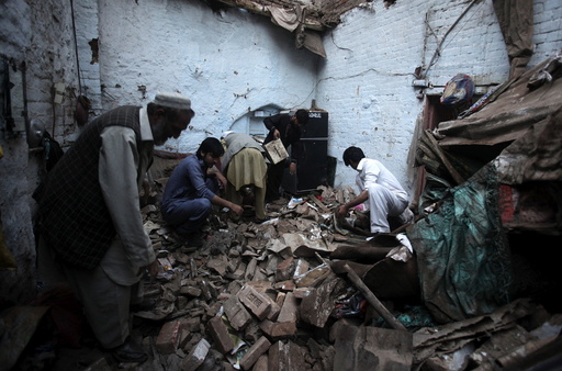 Residents search for belongings in the rubbles of a house after it was damaged by an earthquake in Peshawar