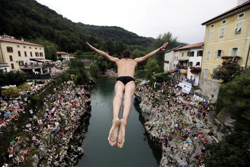 Competitor jumps from the old bridge during a cliff diving competition in Kanal ob Soci