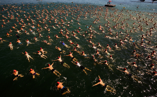 People swim during the annual public Lake Zurich crossing swimming event over a distance of 1,500 metres (4,921 ft) in Zurich