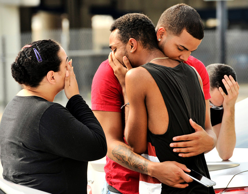 Friends and family members embrace outside the Orlando Police Headquarters after a shooting at the Pulse night club in Orlando