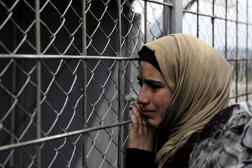 A refugee cries next to the border fence of the Greek-Macedonian borderas during a protest by stranded refugees who wait for the border crossing to reopen near the Greek village of Idomeni