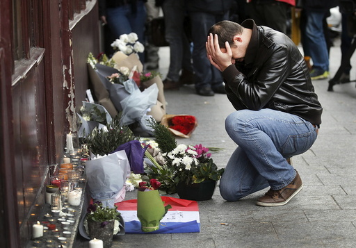 A man pays his respect outside the Le Carillon restaurant the morning after a series of deadly attacks in Paris