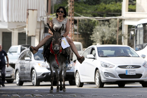 A woman rides a donkey during a donkey race in Roum village