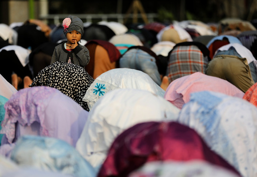People attend prayers for the Muslim holiday of Eid Al-Adha on a street outside of a mosque in Jakarta