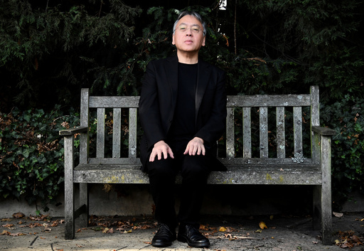Author Kazuo Ishiguro poses for the media outside his home, following the announcement that he has won the Nobel Prize for Literature, in London