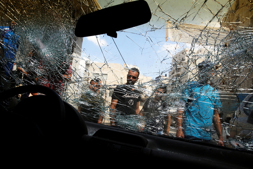 Palestinians surround the car of Palestinian Mustafa Nimer, who Israeli police said attempted to ram policemen and was consequently shot and killed this morning by Israeli security forces, in the refugee camp of Shuafat camp near Jerusalem