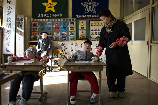Tsukimi Ayano stands in a classroom with scarecrows at a closed down school in the village of Nagoro