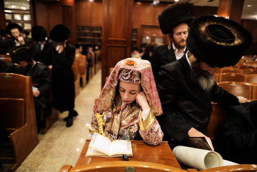 A boy, dressed up in Purim costumes, takes part in the reading from the Book of Esther ceremony performed on the Jewish holiday of Purim, in Jerusalem