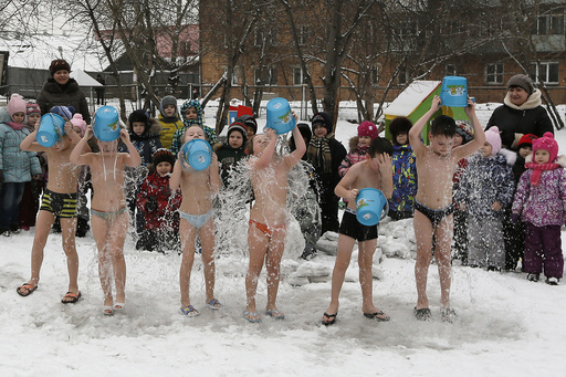 Children watch their classmates pour cold water on themselves, under the watch of fitness coach Oksana Kabotko, as part of a health and fitness program at a local kindergarten in subzero temperatures, in Krasnoyarsk
