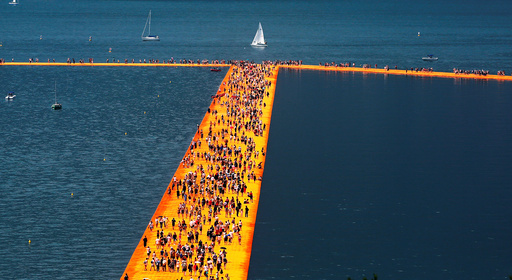 People walk on the installation 'The Floating Piers' by Bulgarian-born artist Christo Vladimirov Yavachev, known as Christo, on the Lake Iseo
