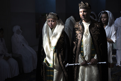 A bride and groom wearing traditional Eritrean dress arrive for their wedding at a Christian Orthodox church in Jerusalem