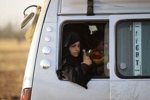 An Iraqi refugee girl that fled violence in Mosul rides a van upon arrival in al-Kherbeh village