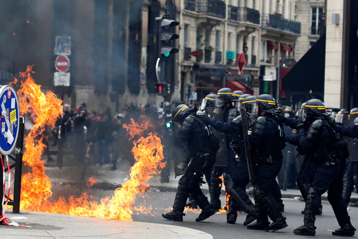 French CRS riot police protect themselves from flames during clashes at the traditional May Day labour union march in Paris