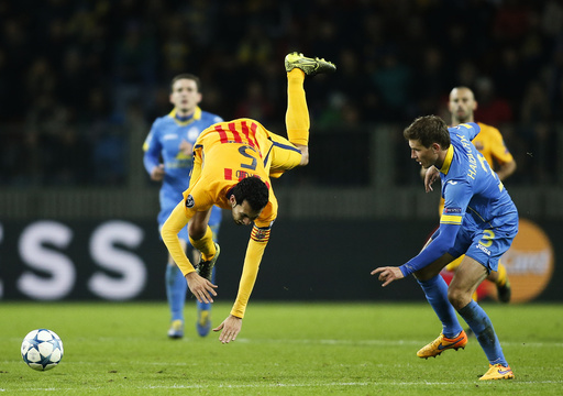 Barcelona's Sergio Busquets falls down onto pitch next to BATE Borisov's Gaiduchik during their Champions League group E soccer match at Borisov Arena stadium outside Minsk