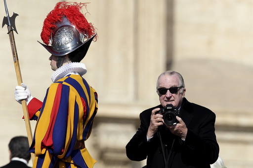 Belgium's King Albert II holds a camera in St. Peter's square before Pope Francis leads the Easter mass at the Vatican