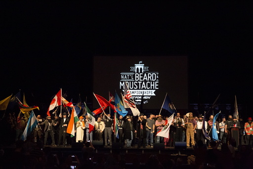 Contestants wave flags to commence the 2015 Just For Men National Beard & Moustache Championships at the Kings Theater in the Brooklyn borough of New York