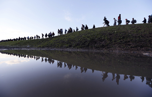 Migrants make their way on foot on the outskirts of Brezice