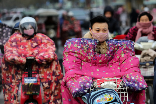 People wear special jackets made for riders to keep out the wind during a cold day in Lianyungang