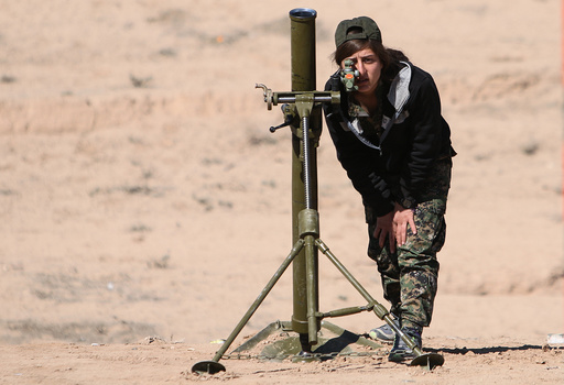A Syrian Democratic Forces (SDF) female fighter adjusts a mortar in northern Deir al-Zor province ahead of an offensive against Islamic State militants
