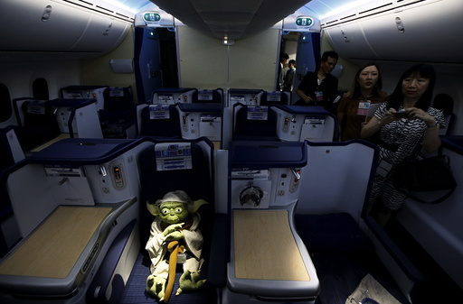 Visitors look at a Yoda plush toy sitting in the business class section during a tour of the 