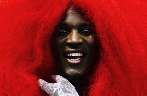 A person wears a giant red wig as the take part in the Gay Pride Parade in Toronto