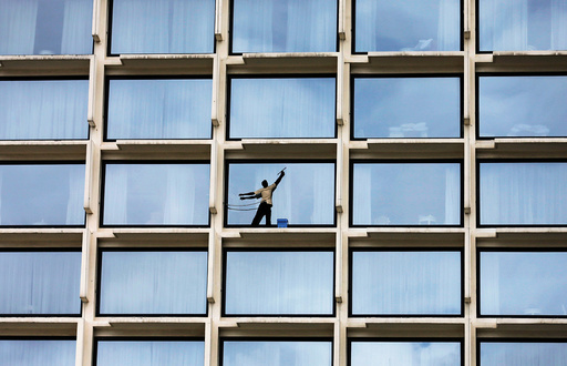 A worker cleans the windows of a luxury hotel in Colombo