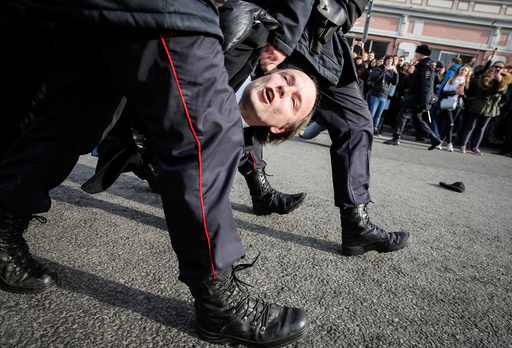 Law enforcement officers detain an opposition supporter during a rally in Moscow, Russia