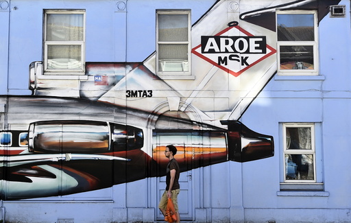 A resident walks past a house covered with a painted mural in Brighton