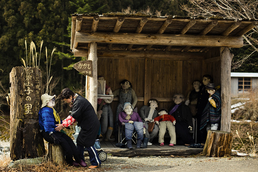 Tsukimi Ayano arranges a scarecrow at a bus stop in the mountain village of Nagoro