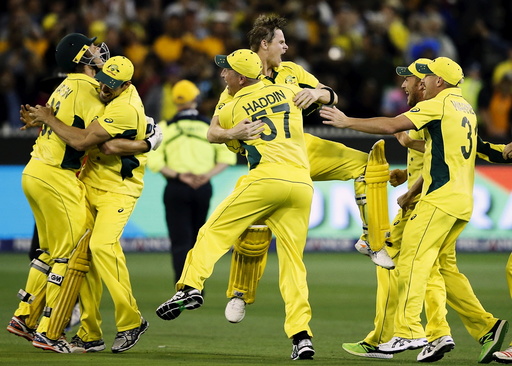 Australian players celebrate after defeating New Zealand in their Cricket World Cup final match at the MCG