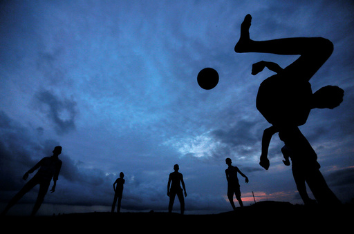 A boy kicks a ball as he plays soccer with his friends at Galle Dutch Fort in Galle
