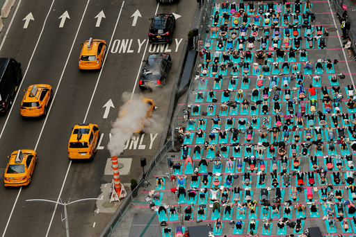 People participate in a yoga class during an annual Solstice event in the Times Square district of New York
